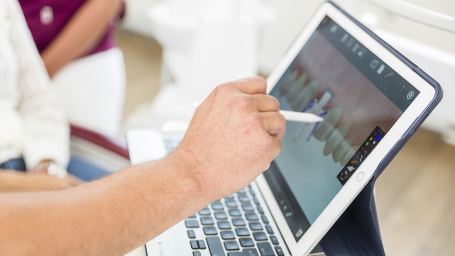 Implantatplanung: Besprechung eines Röntgenbefunds am Tablet in der DOC Praxisklinik Neu-Ulm